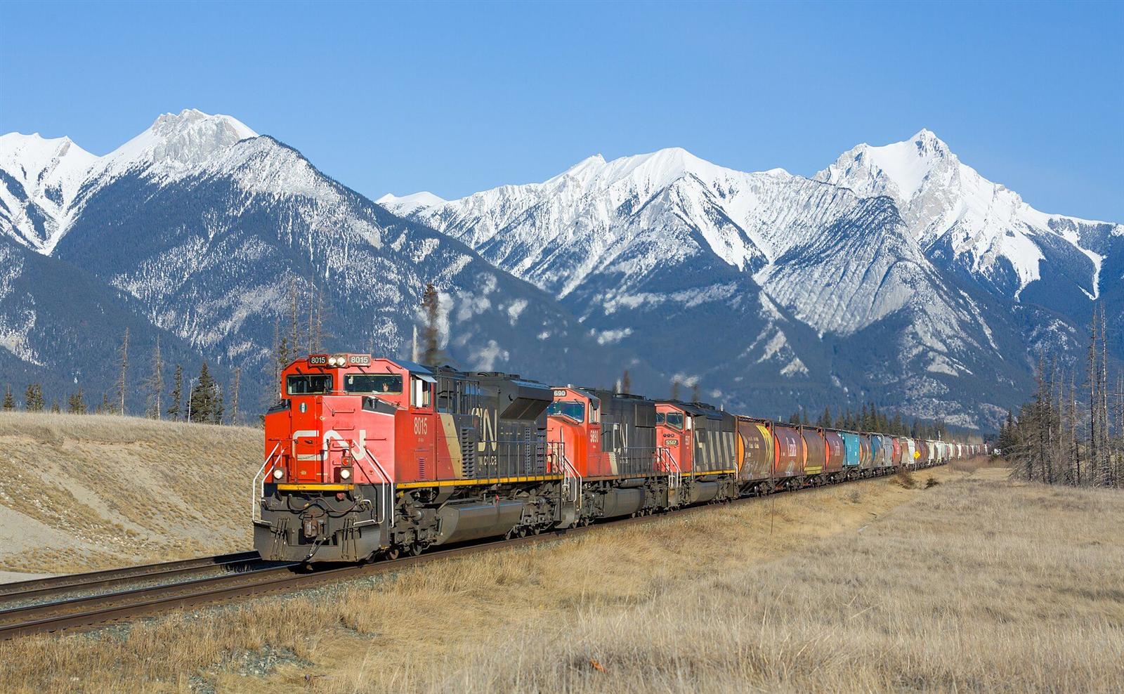 A Canadian National freight train beneath mountain peaks between Hinton and Jasper, Alberta